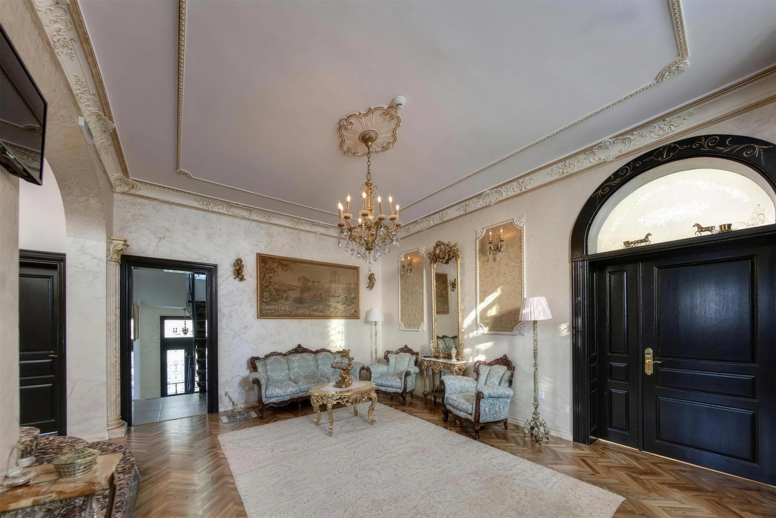 Salonul vilei, cu candelabru de cristal, stucaturi și mobilier de epocă